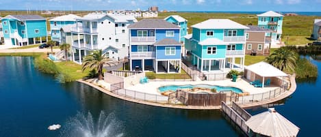 Um imóvel à beira-mar com várias casas, piscina e um cais.