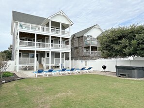 Un bâtiment à deux étages doté d’un balcon et d’un espace piscine avec des chaises longues.