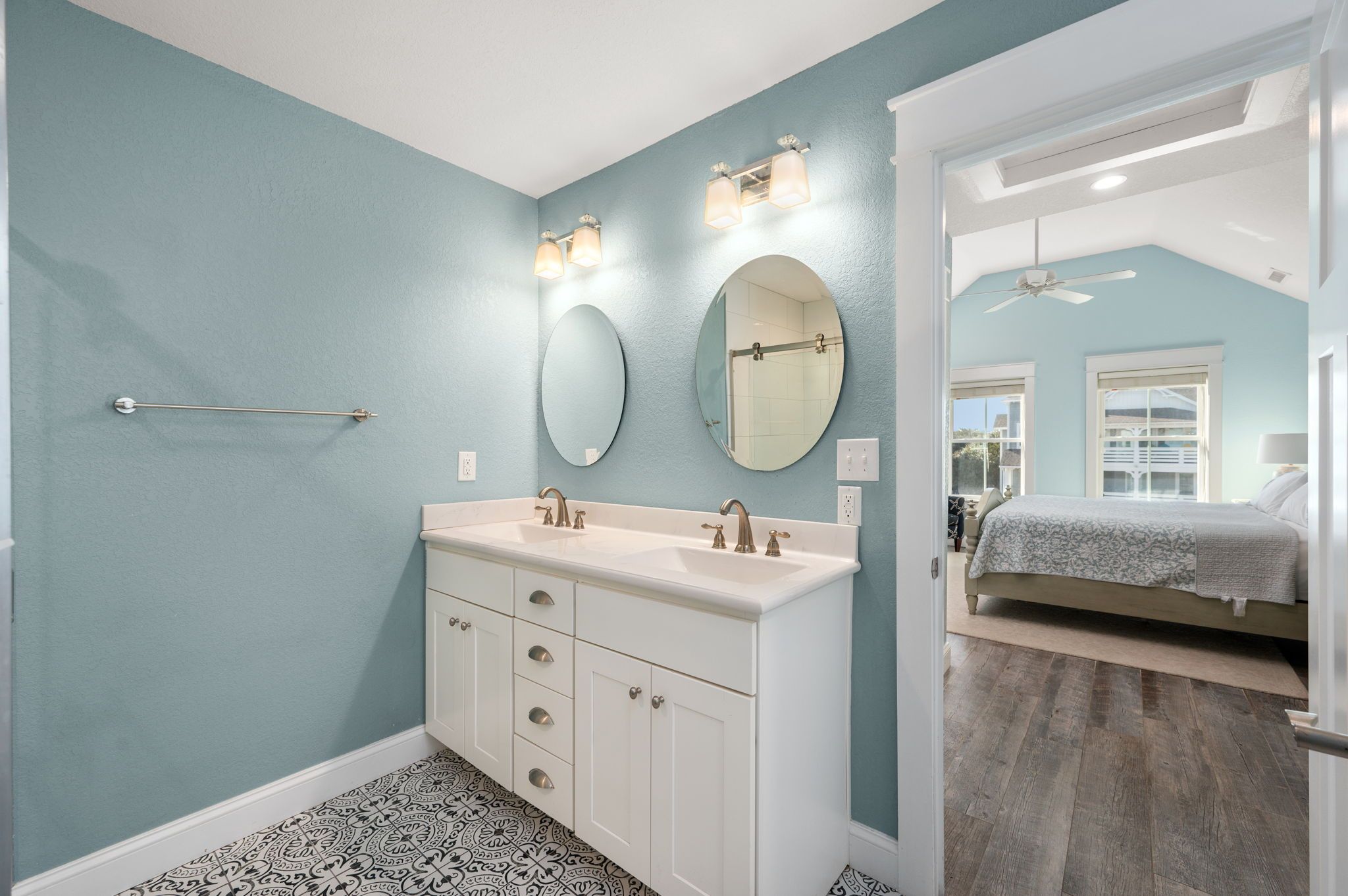 A bathroom with a large vanity, two mirrors, and a towel rack.