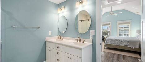 A bathroom with a large vanity, two mirrors, and a towel rack.