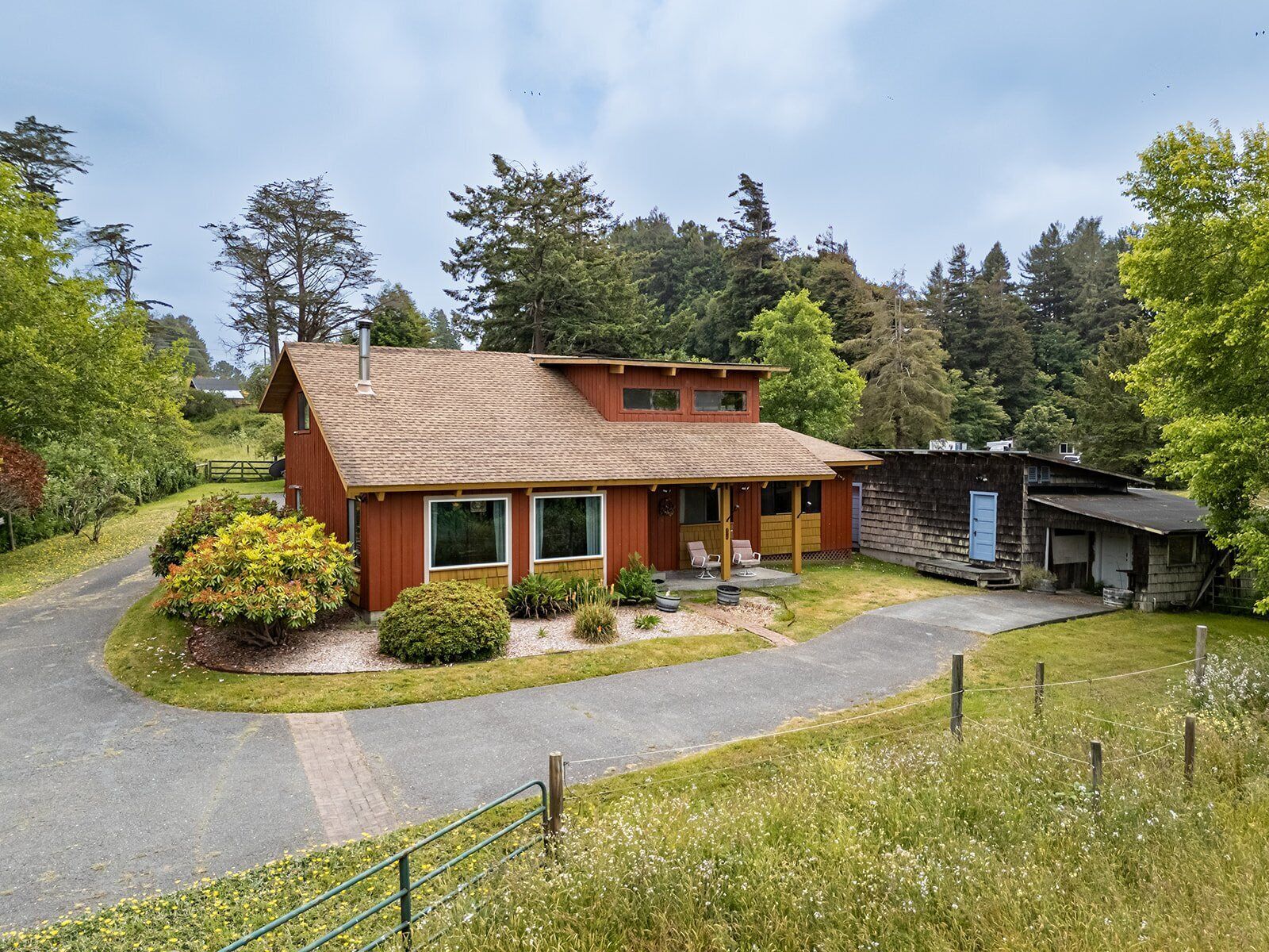 A two-story house with a sloped roof, a front porch, and a garage.