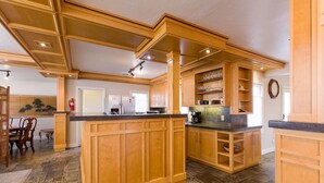 Une cuisine spacieuse dotée de meubles en bois, d’un îlot central et d’un coin repas au décor traditionnel.