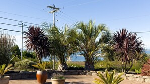 Un'area patio con piante in vaso e vista sul mare.