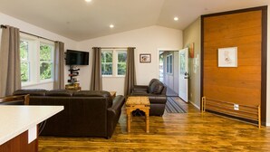 A modern living room with a sofa, a coffee table, and a television.