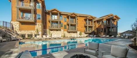 A multi-story building with a pool and outdoor seating area.