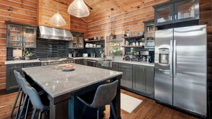 Una cocina moderna con una isla grande, electrodomésticos de acero inoxidable y paneles de madera.