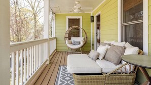 A covered porch with a wicker chair, a sofa, and a table. - Spacious 3-bedroom house on the Beltline in Atlanta (Atlanta)