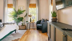 A bedroom with a bed, a desk, a chair, and two potted plants. - Spacious 3-bedroom house on the Beltline in Atlanta (Atlanta)