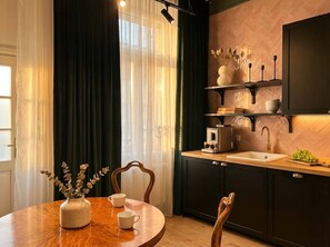 Una cocina moderna con una mesa redonda de madera, una cafetera y un lavabo.