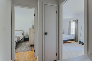 A bedroom with a bed, bedside table, and a window with curtains.