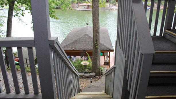 Un escalier en bois mène à une jetée sur laquelle se trouve une petite construction à l’extrémité.
