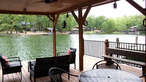 Une terrasse couverte avec des sièges et une vue sur un lac.