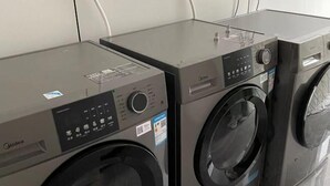 Una hilera de lavadoras compactas y modernas con paneles de control y una pequeña pantalla.