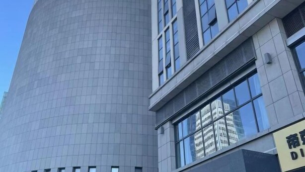 Un edificio moderno con fachada curva y grandes ventanales.