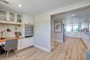 Une cuisine moderne avec des armoires blanches, un four encastré et un plan de travail en bois.