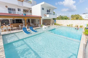A swimming pool with lounge chairs and a bar area. - Casual On the Beach Bayahibe by Casual Hoteles (Bayahíbe)