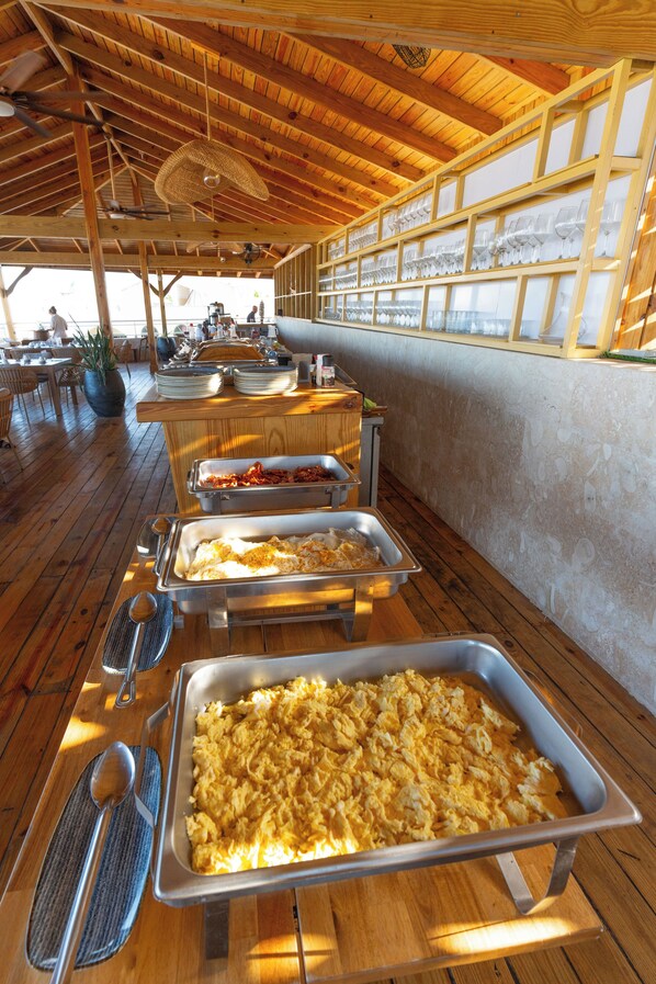 A buffet setup with various food items and utensils. - Casual On the Beach Bayahibe by Casual Hoteles (Bayahíbe)