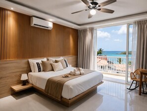 A modern bedroom with a large bed, a ceiling fan, an air conditioning unit, and a balcony with a view of the ocean. - Casual On the Beach Bayahibe by Casual Hoteles (Bayahíbe)