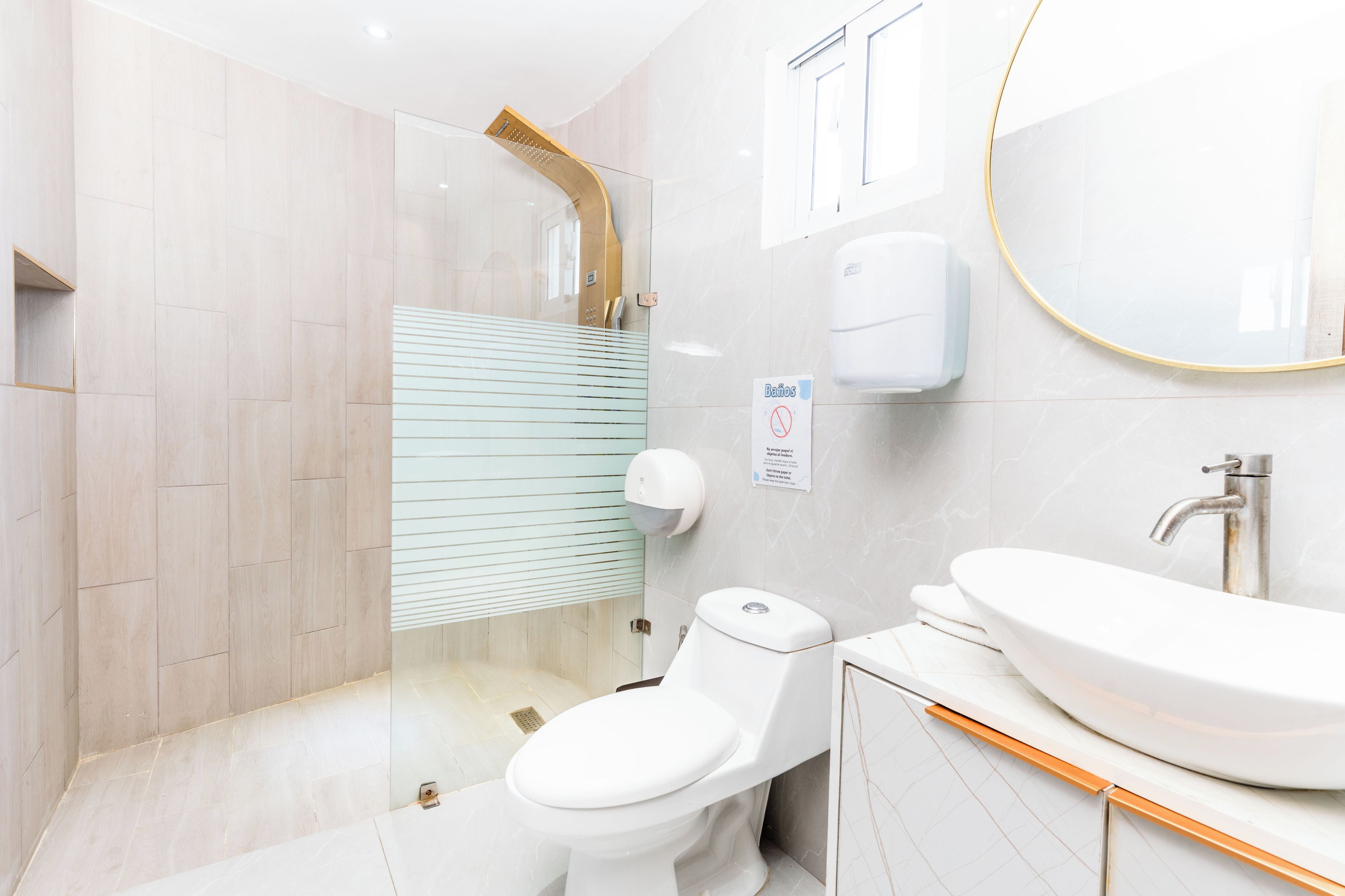 A modern bathroom with a toilet, sink, and shower.