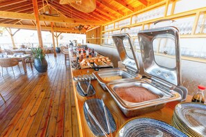 A buffet setup with various food items and utensils. - Casual On the Beach Bayahibe by Casual Hoteles (Bayahíbe)