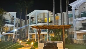 A modern hotel with multiple floors, outdoor seating areas, and palm trees. - Zafiro 316 Acapulco Diamante (Acapulco de Juárez)