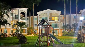 A hotel with multiple buildings, a playground with a slide, and palm trees. - Zafiro 316 Acapulco Diamante (Acapulco de Juárez)