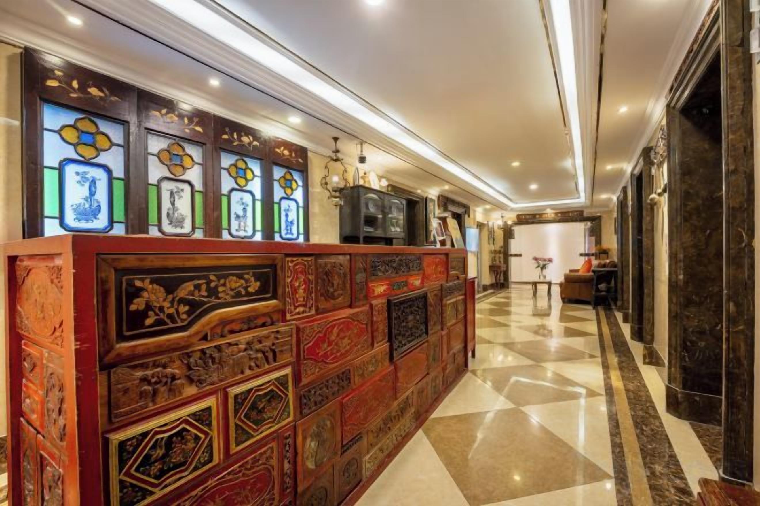 Un vestíbulo de hotel con mostrador de recepción, una araña y un mostrador de registro.