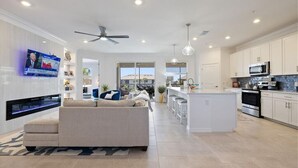 Una cocina moderna con armarios blancos, una isla central y electrodomésticos de acero inoxidable.
