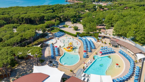 An aerial view of a resort with multiple swimming pools, sun loungers, and a view of the sea. - Cosy apartment in villa for 4 guests with WIFI, A/C, pool, TV and terrace (Castiglione Della Pescaia)