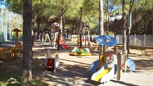 A playground with various play structures, including slides and swings, surrounded by trees. - Cosy apartment in villa for 4 guests with WIFI, A/C, pool, TV and terrace (Castiglione Della Pescaia)