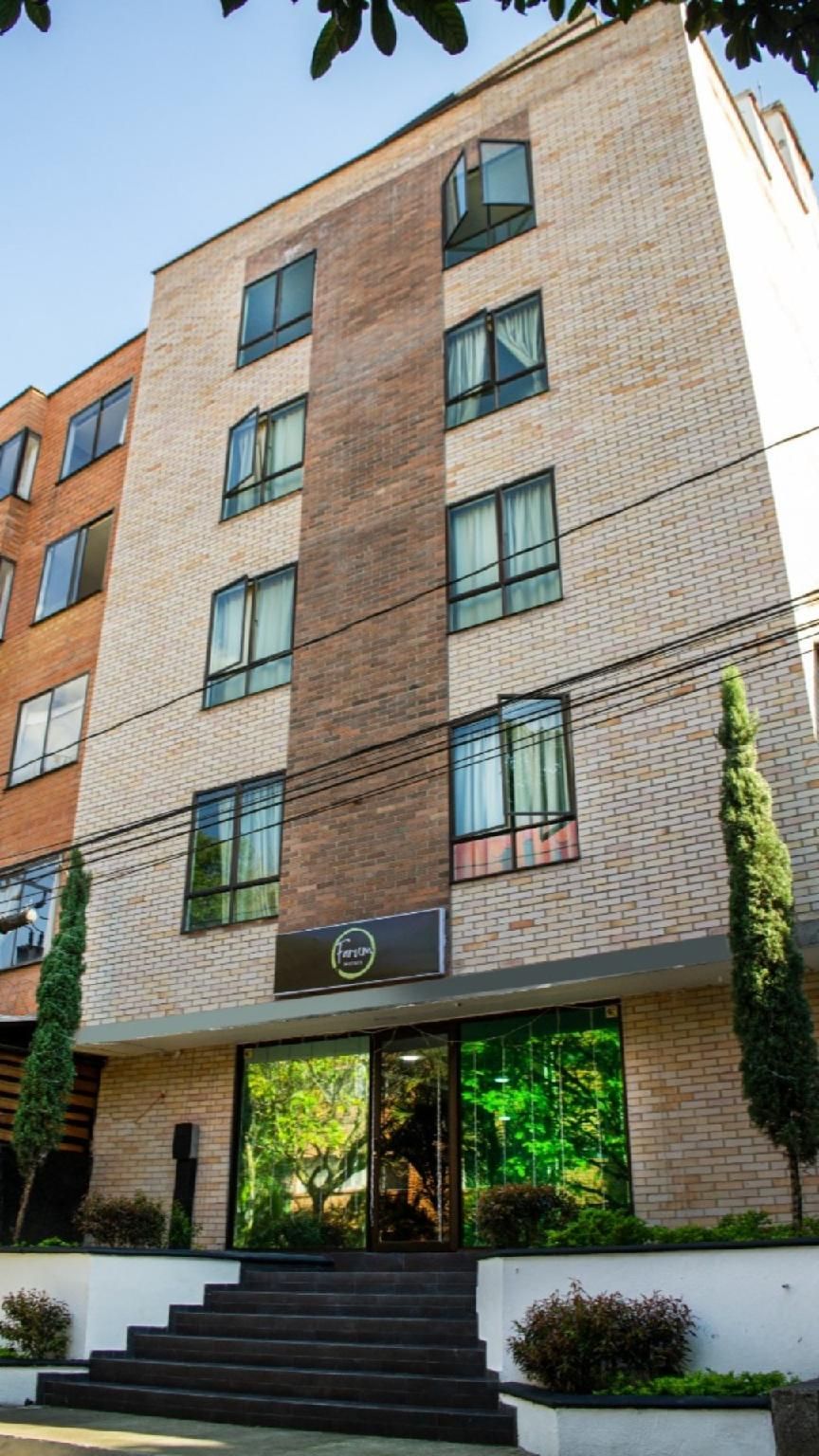 A multi-story building with a brick facade, large windows, and a staircase leading to the entrance.