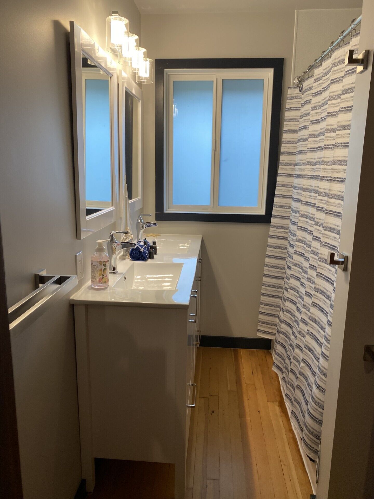 A compact bathroom with a window, a sink, and a shower curtain.