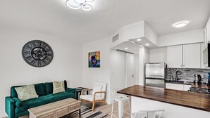 Een moderne keuken met witte kastjes, een roestvrijstalen koelkast en een houten aanrecht.