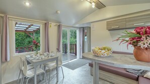 A modern kitchen with a dining area, a bench, and a view of the outdoors. - Pet friendly (sta)caravan in Irrhausen (Irrhausen)