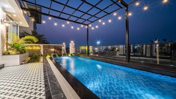 Una piscina al aire libre, sillones reclinables de piscina