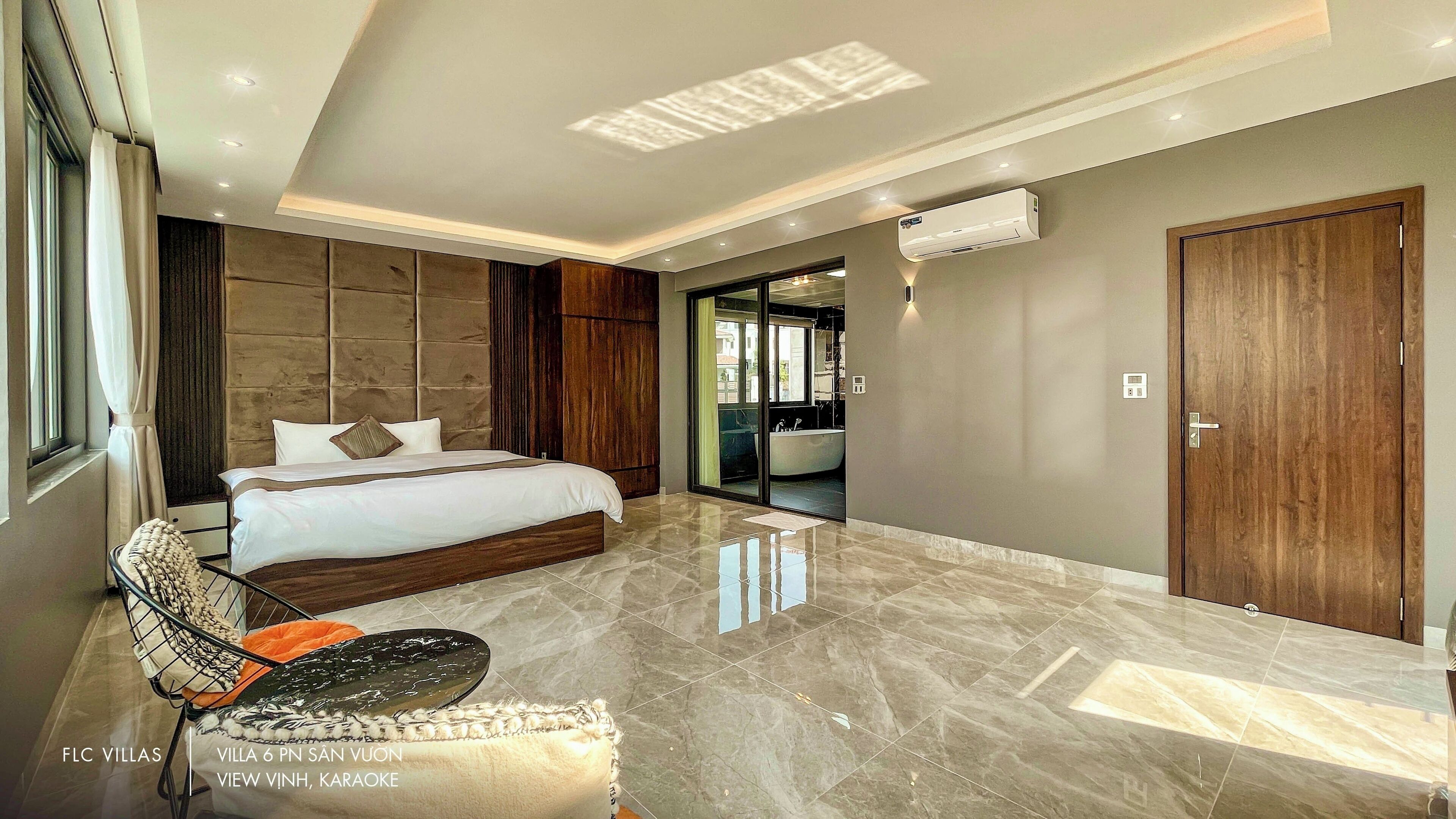 Un dormitorio moderno con una cama grande, un tocador y vistas al exterior.