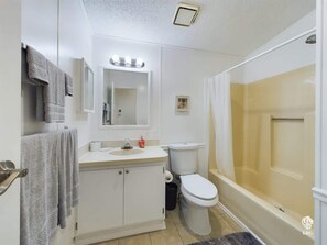 Une salle de bain comprenant des toilettes, un lavabo, un miroir et une douche.