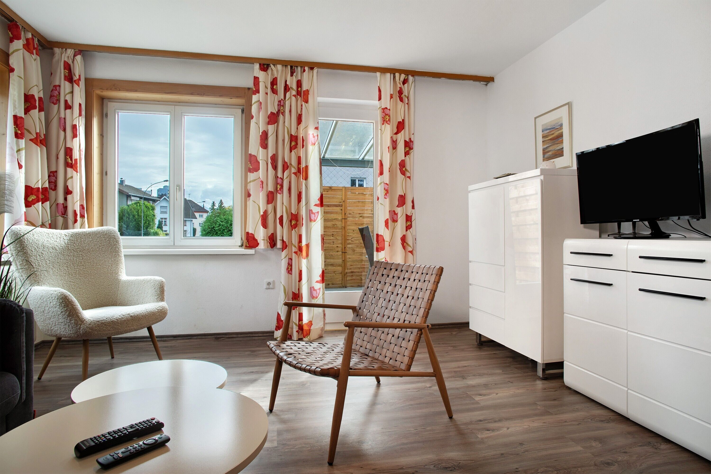 A living room with a sofa, a chair, a TV, and a cabinet.