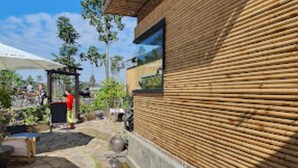 A courtyard with stone flooring, a bamboo wall, and a small water feature. - Long Co Tran Homestay (Lung Cu)