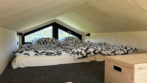 A small, cozy room with a bed, a window, and a wooden headboard. - Tiny Home 'Zuhause Im Freien' with Air Conditioning (Stockach)