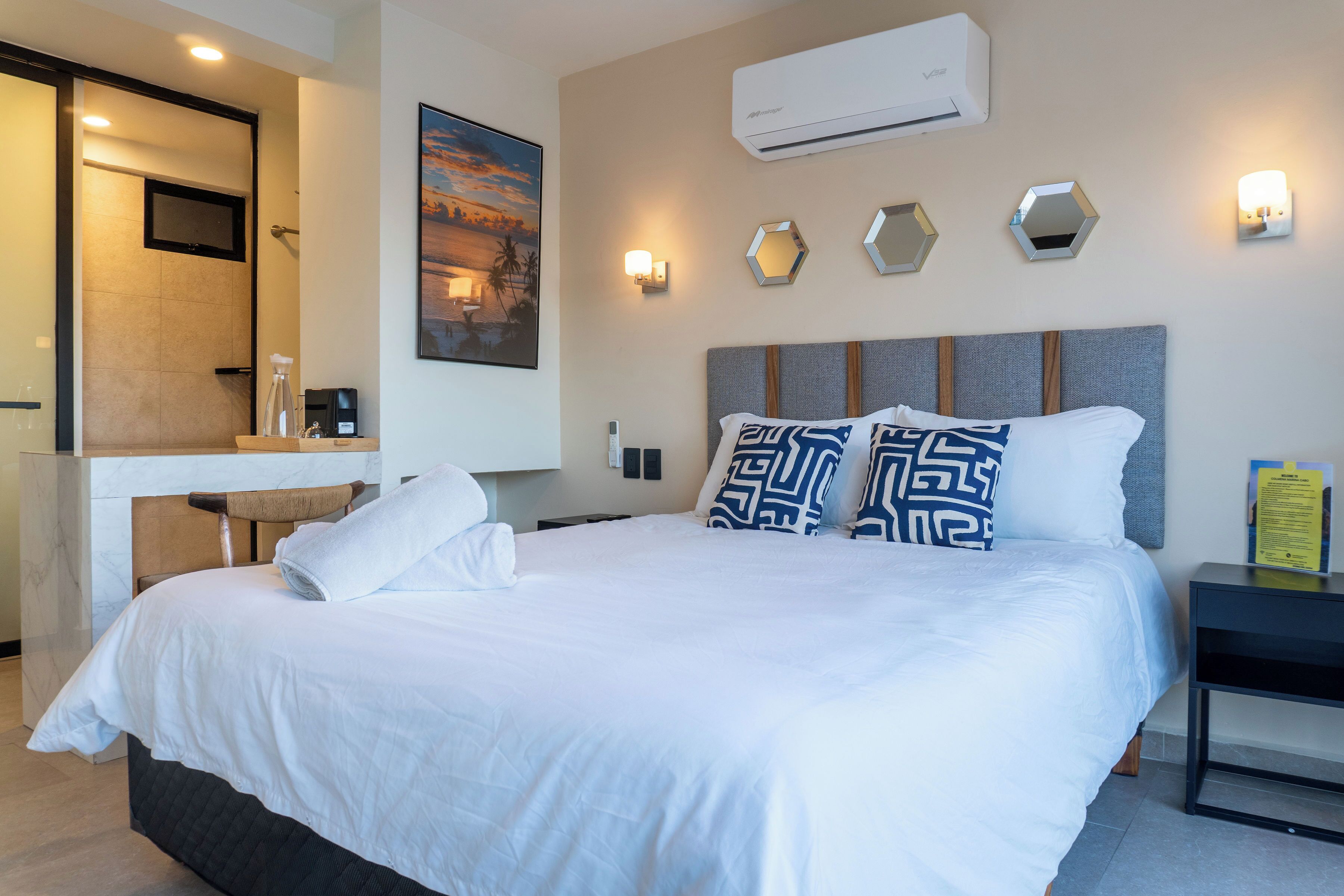 Habitación de hotel con una cama grande, un escritorio y zona de ducha.