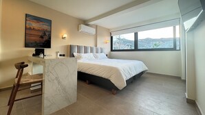 Et moderne hotelværelse med seng, skrivebord og stol.