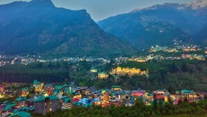 A town nestled in a valley with mountainous terrain in the background. - Hotel Swastik Grand (Manali)