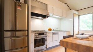 Eine kompakte Küche mit eingebautem Backofen, Mikrowelle und einem Edelstahlkühlschrank.