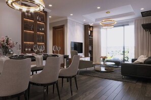 Una sala de estar moderna con comedor, un sofá y un televisor.