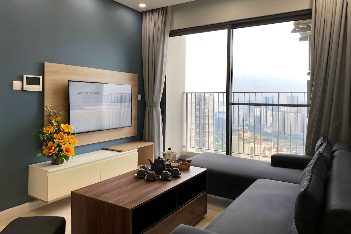 A modern living room with a large TV, a coffee table, and a sofa.