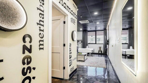 A modern hotel corridor with a polished floor, a seating area with tables and chairs, and a large mirror on the wall. - *New* Loft 5 min Shadyside/East Liberty Sleeps 4 (Pittsburgh)