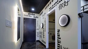 A hallway with a modern design, featuring a marble floor and walls adorned with multilingual words. - *New* Loft 5 min Shadyside/East Liberty Sleeps 4 (Pittsburgh)