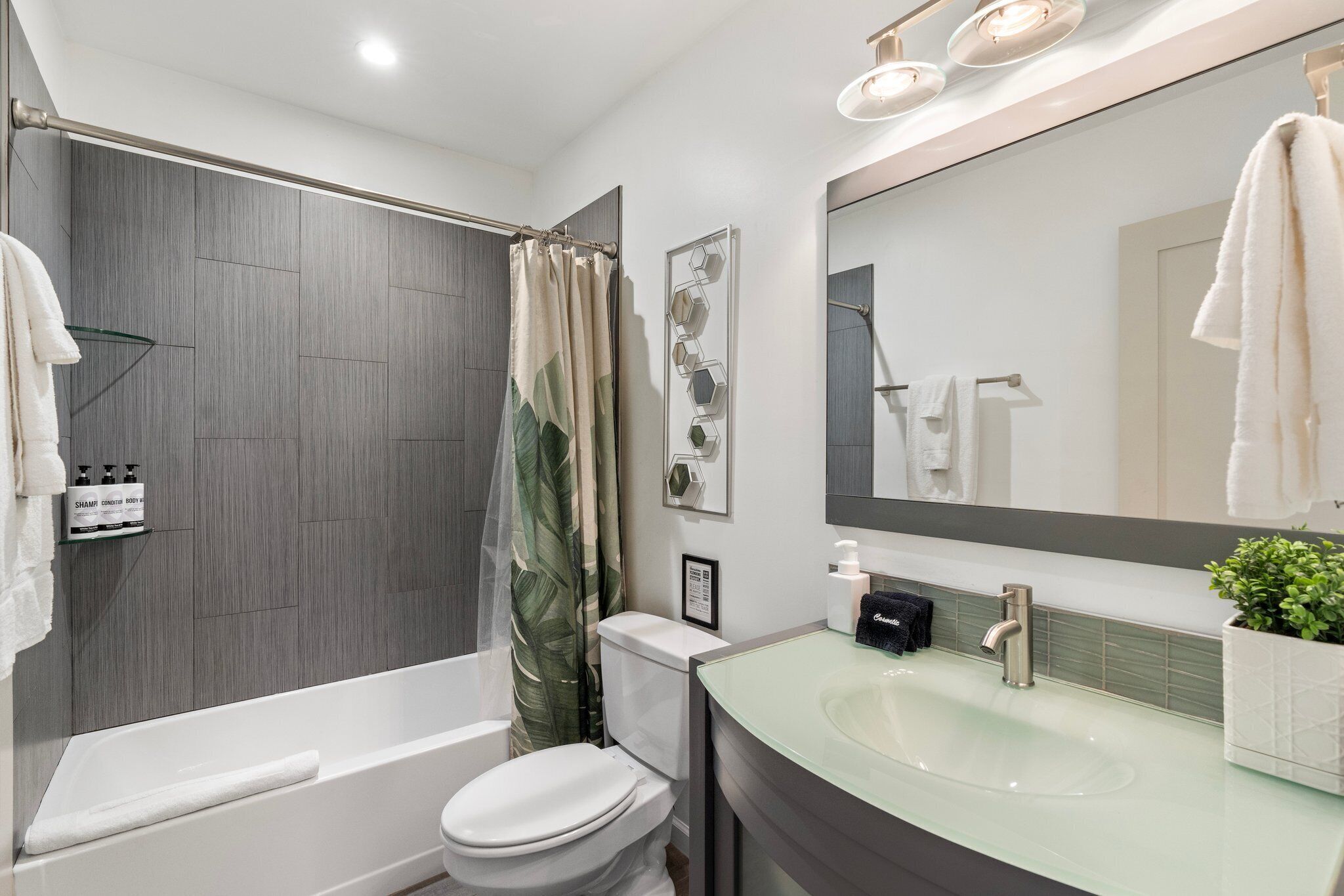 A modern bathroom with a bathtub, toilet, and sink.