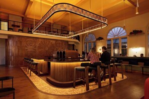 Relax with a drink at the hotel's stylish bar, featuring a curved ceiling and comfortable seating.